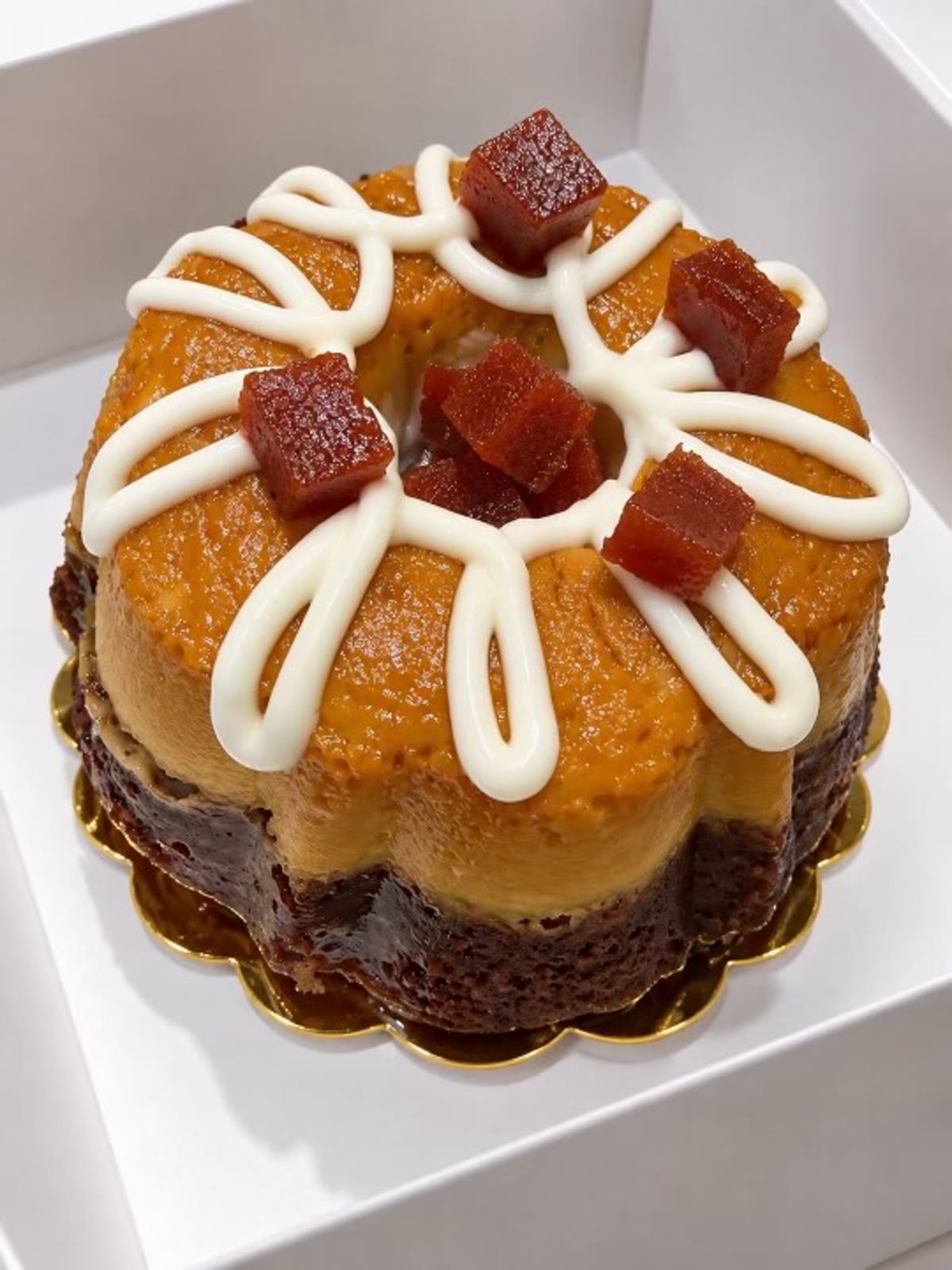 Decorated mini chocoflan with white icing and red fruit pieces