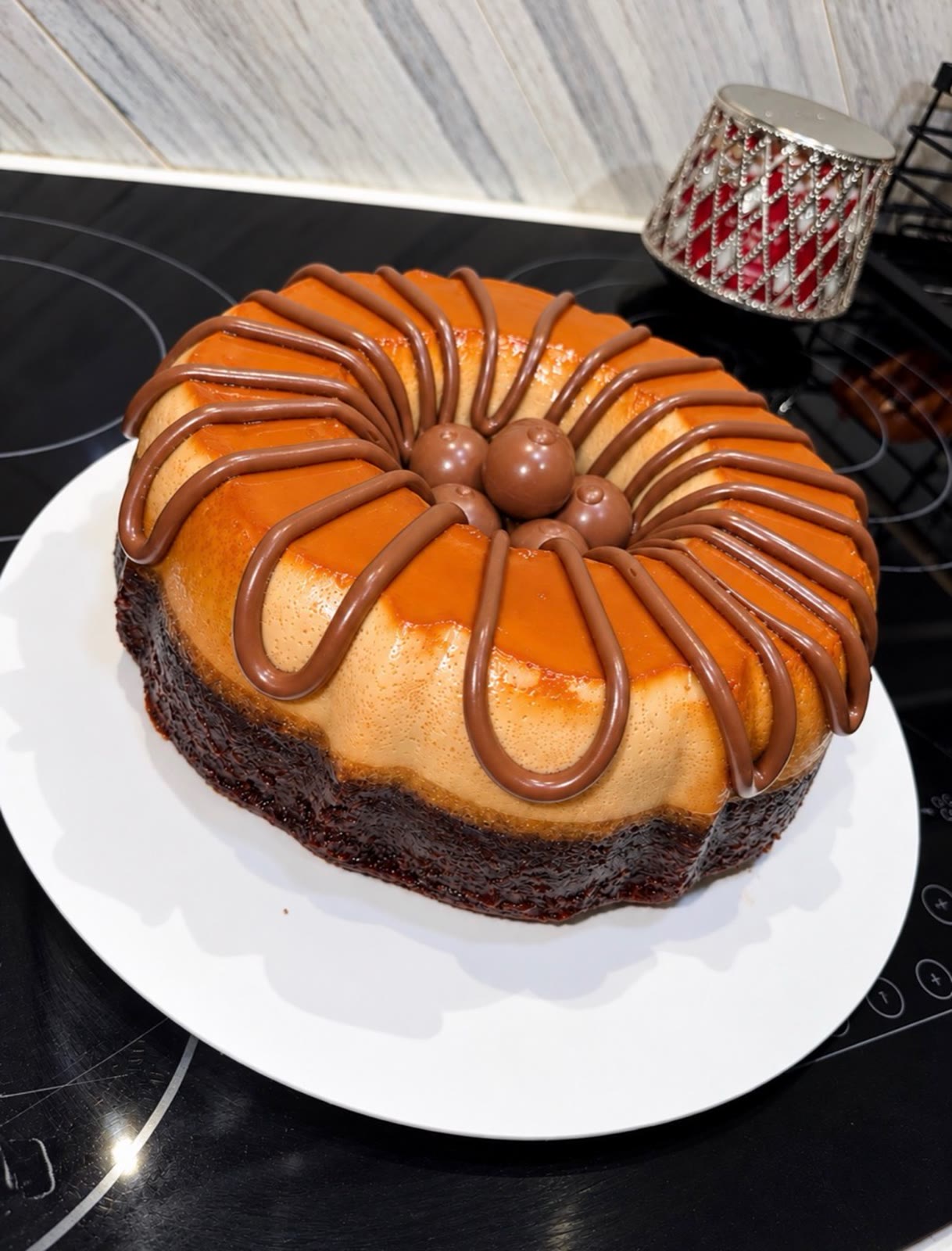 Large ring-shaped chocoflan with chocolate drizzle and chocolate candies