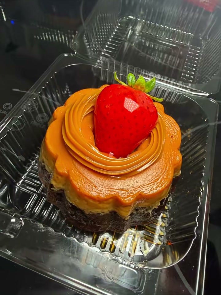 Decorated mini chocoflan with a piped topping and a fresh strawberry